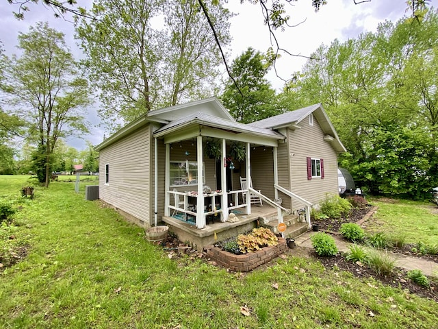 310 W Delta St, Aurora, MO 65605 - view of front facade with a porch, a front yard, and central AC
