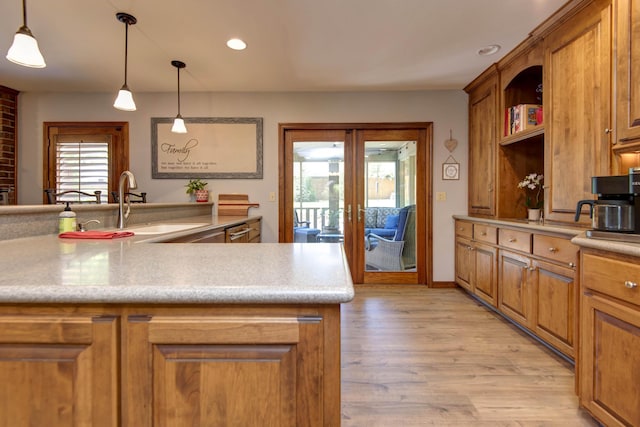 1918 E Buena Vista St, Springfield, MO 65804 - kitchen with brown cabinetry, open shelves, light wood finished floors, a sink, and light countertops