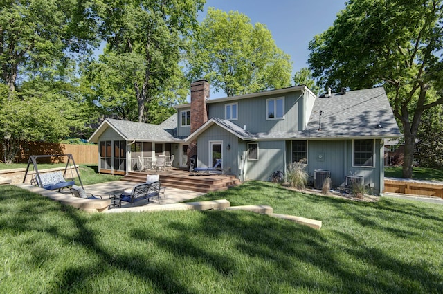 1918 E Buena Vista St, Springfield, MO 65804 - rear view of house featuring a chimney, a sunroom, a shingled roof, a wooden deck, and a patio