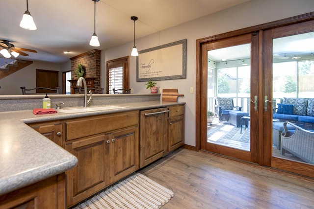 1918 E Buena Vista St, Springfield, MO 65804 - kitchen with a sink, brown cabinets, french doors, pendant lighting, and light wood finished floors
