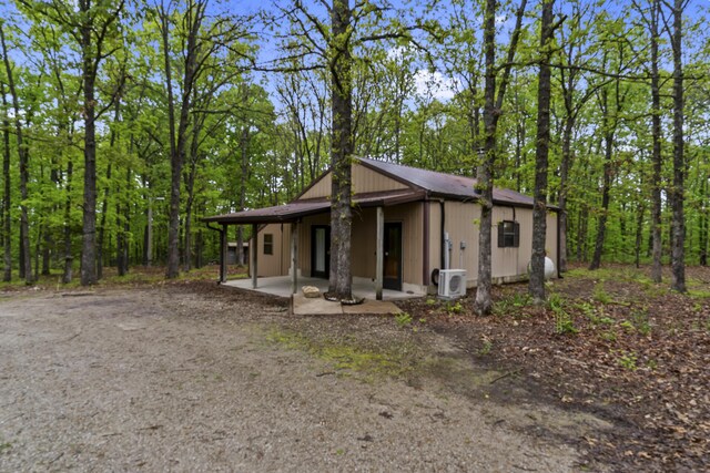 view of front of home with a patio area and a cooling unit