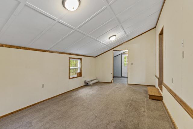 carpeted spare room with vaulted ceiling and baseboards