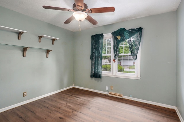 unfurnished room with wood finished floors, ceiling fan, and baseboards