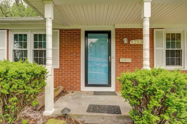 entrance to property with brick siding and covered porch