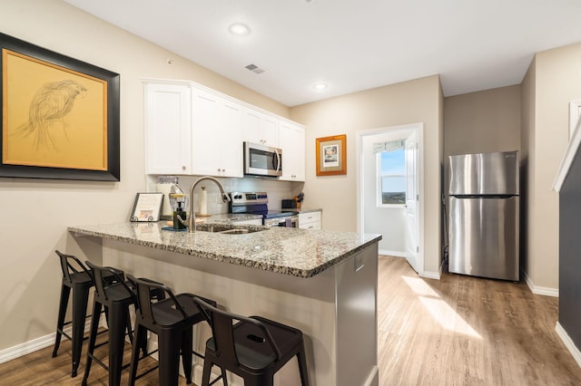 3112 S Vinyards Terrace Parkway Unit 4, Branson, MO 65616 - kitchen featuring stainless steel appliances, a sink, baseboards, light wood finished floors, and white cabinetry