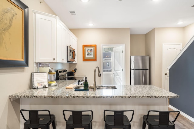 3112 S Vinyards Terrace Parkway Unit 4, Branson, MO 65616 - kitchen with stainless steel appliances, a peninsula, a sink, light stone countertops, and recessed lighting