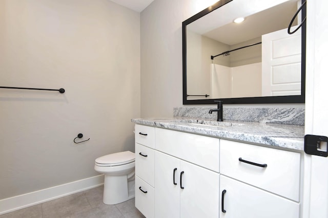 bathroom with baseboards, vanity, tile patterned floors, toilet, and a shower