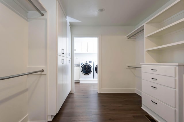 walk in closet featuring washing machine and clothes dryer and dark wood-style flooring