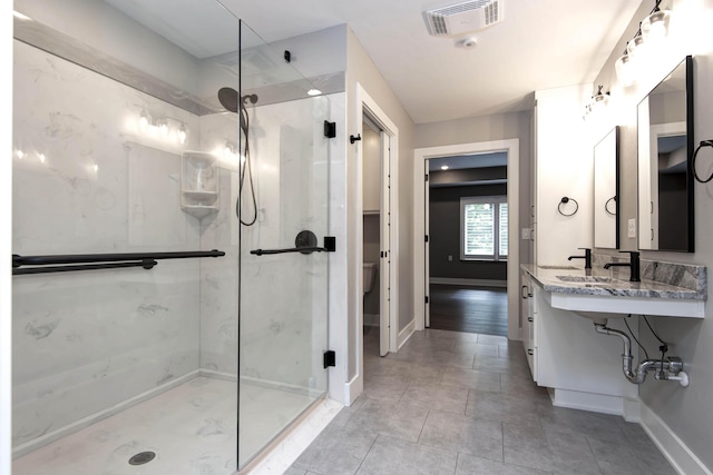 full bathroom featuring a stall shower, baseboards, a sink, and toilet