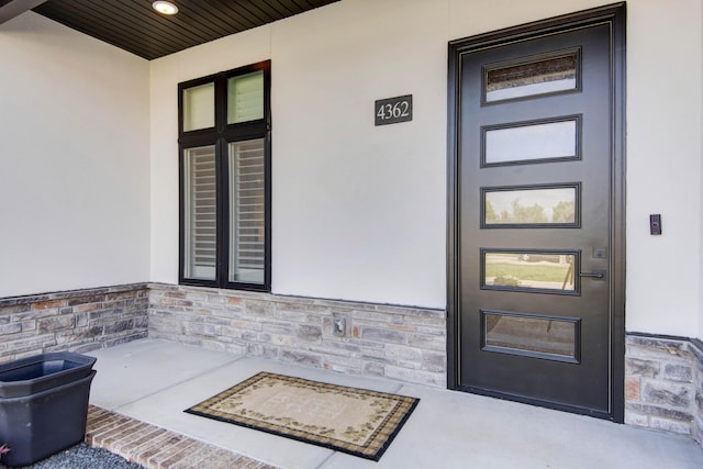 entrance to property with stucco siding and stone siding