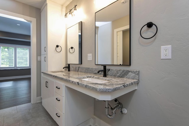 bathroom featuring a sink, tile patterned floors, and baseboards