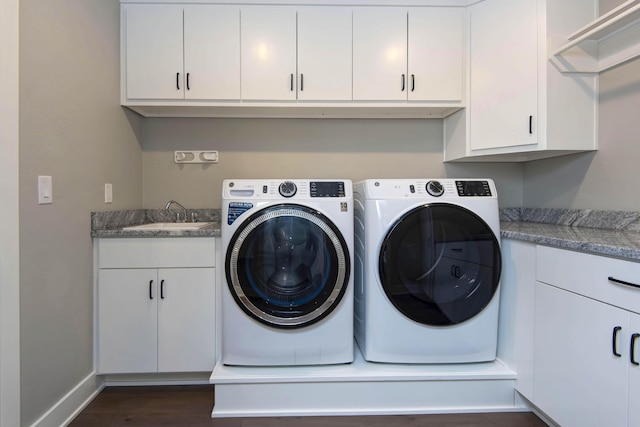 clothes washing area with washer and dryer, cabinet space, dark wood-style floors, and baseboards