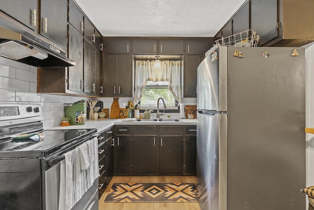 311 S Center St, Fordland, MO 65652 - kitchen with stainless steel appliances, under cabinet range hood, a sink, light countertops, and backsplash