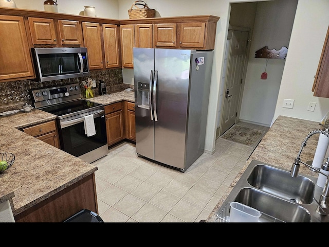 71 Birdie Ln Unit 3, Branson West, MO 65737 - kitchen with appliances with stainless steel finishes, a sink, brown cabinetry, and decorative backsplash