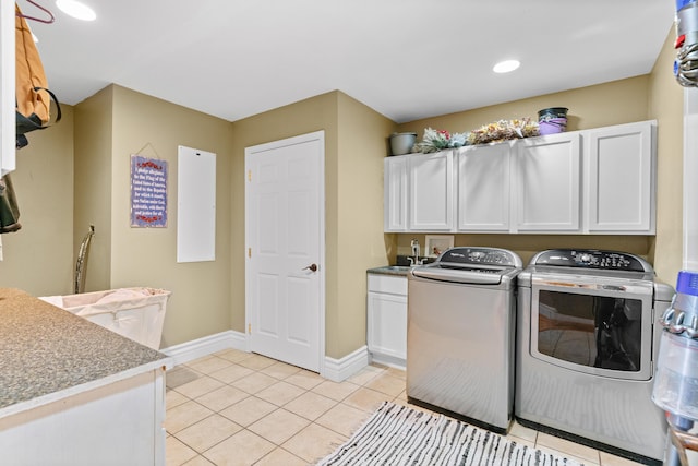 washroom with cabinet space, washing machine and dryer, light tile patterned floors, baseboards, and recessed lighting
