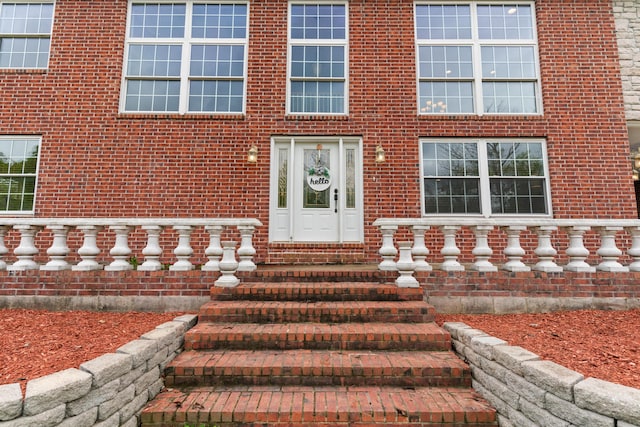 doorway to property with brick siding