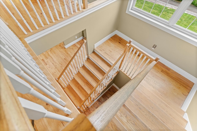 staircase with baseboards and wood finished floors