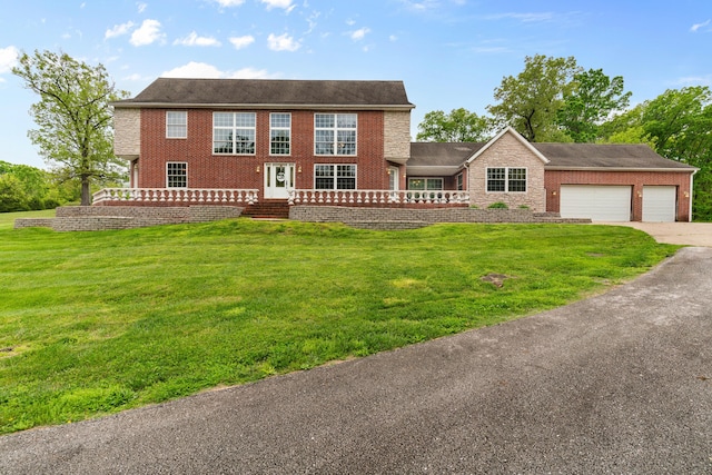 view of front of house with brick siding, an attached garage, concrete driveway, and a front yard