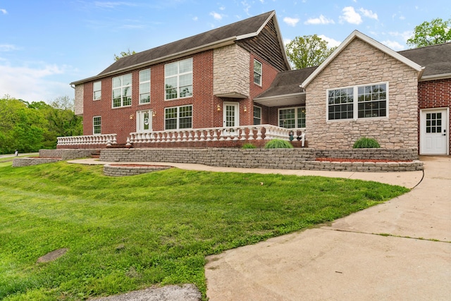 view of front of property with stone siding and a front lawn