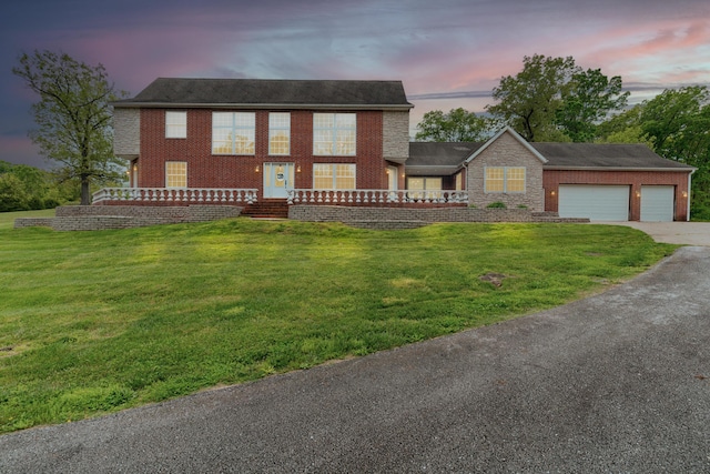 view of front facade featuring concrete driveway, an attached garage, a front lawn, and brick siding