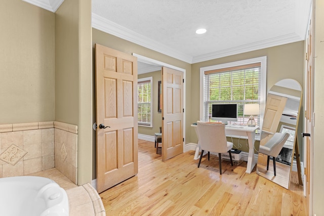 office featuring light wood-style flooring, ornamental molding, and a textured ceiling