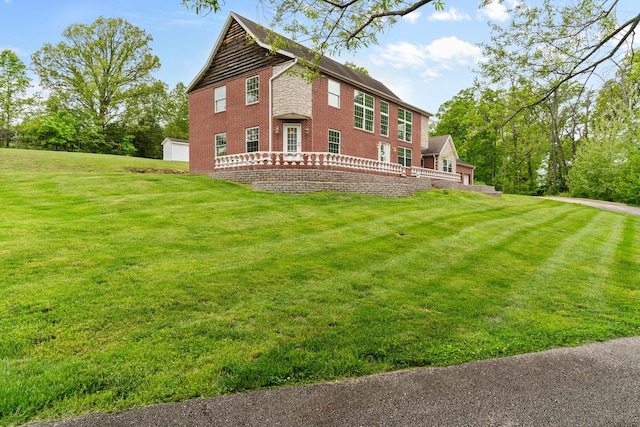 back of house with a lawn and brick siding