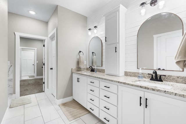 bathroom featuring double vanity and baseboards
