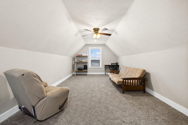 living area featuring vaulted ceiling, carpet flooring, baseboards, and ceiling fan