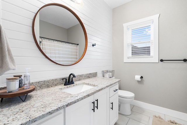 full bath featuring wood walls, vanity, toilet, and baseboards