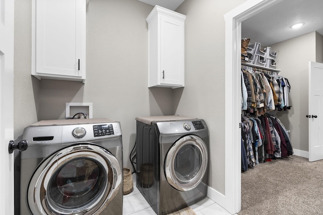 laundry room featuring washing machine and dryer, cabinet space, baseboards, and light colored carpet