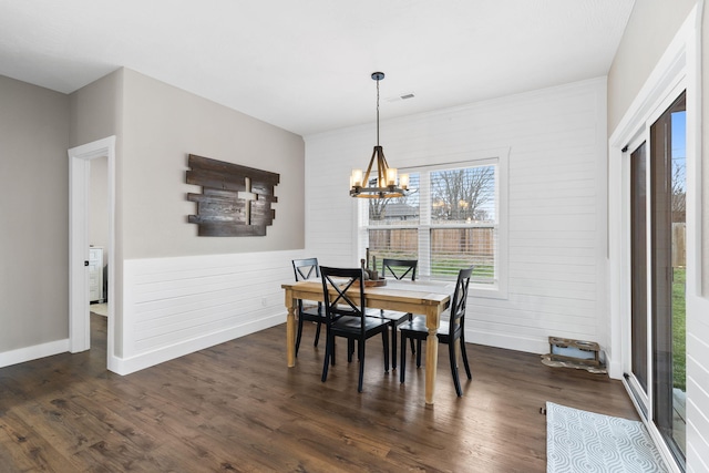 dining space featuring a chandelier, dark wood-style flooring, and baseboards