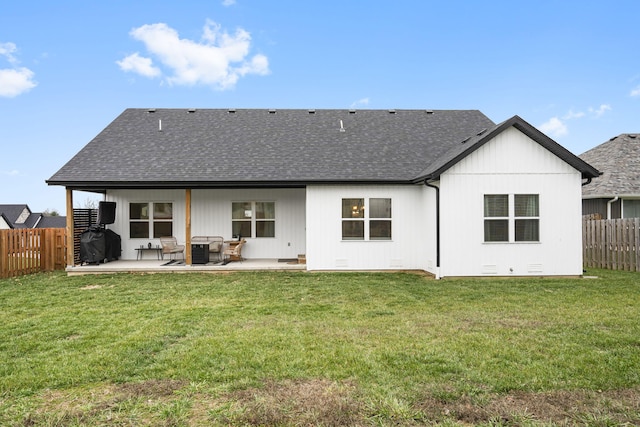 back of house featuring a patio area and a shingled roof