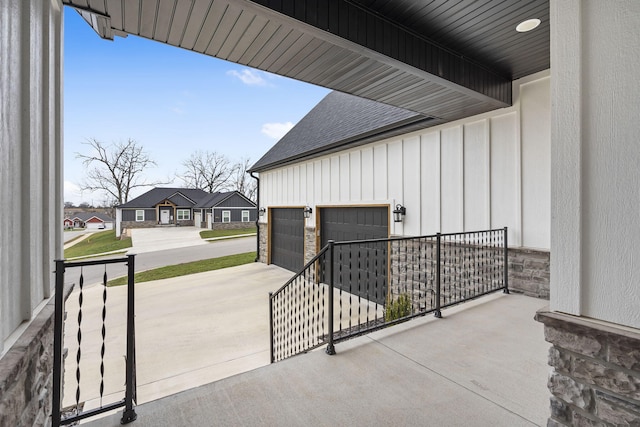 view of patio with concrete driveway, a garage, and covered porch