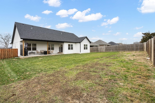 back of property with a shingled roof and a patio