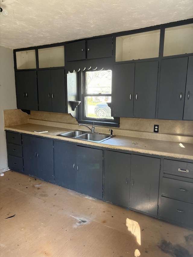 kitchen featuring a sink, gray cabinetry, light countertops, and a textured ceiling