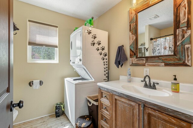 167 Motel Ln, Cape Fair, MO 65624 - full bathroom featuring estacked washer and dryer, wood finished floors, vanity, and baseboards