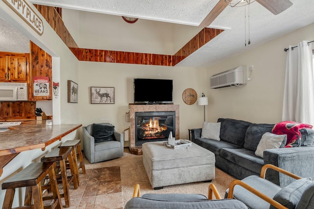 167 Motel Ln, Cape Fair, MO 65624 - living room featuring a textured ceiling, a glass covered fireplace, a wall unit AC, and ceiling fan