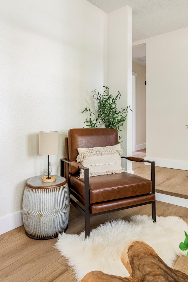 living area featuring baseboards and wood finished floors