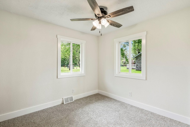 unfurnished room featuring plenty of natural light, baseboards, carpet, and ceiling fan
