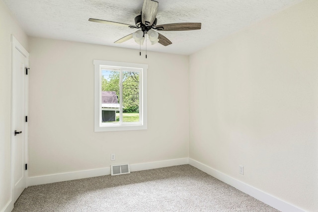 spare room featuring light carpet, baseboards, a textured ceiling, and a ceiling fan