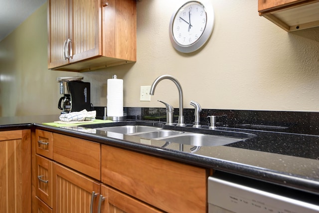 186 Bunker Ridge Dr Unit 2, Branson, MO 65616 - kitchen featuring dishwasher, a sink, brown cabinets, and dark stone countertops