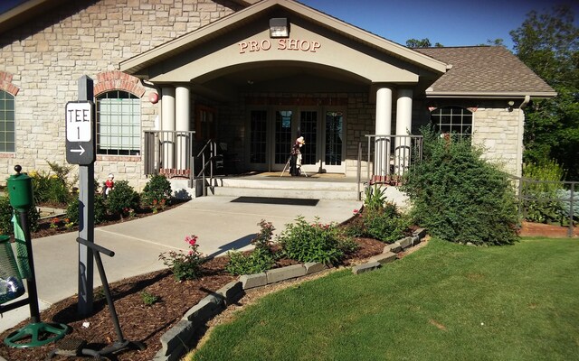 186 Bunker Ridge Dr Unit 2, Branson, MO 65616 - entrance to property with stone siding, roof with shingles, a yard, and covered porch