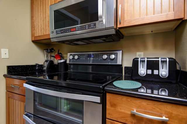 186 Bunker Ridge Dr Unit 2, Branson, MO 65616 - kitchen with appliances with stainless steel finishes, dark countertops, and brown cabinets
