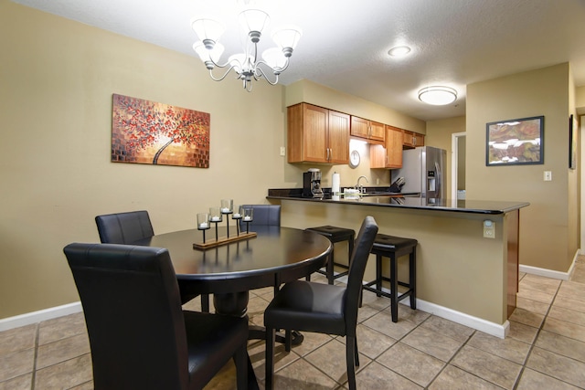 186 Bunker Ridge Dr Unit 2, Branson, MO 65616 - dining space with a chandelier, light tile patterned floors, and baseboards