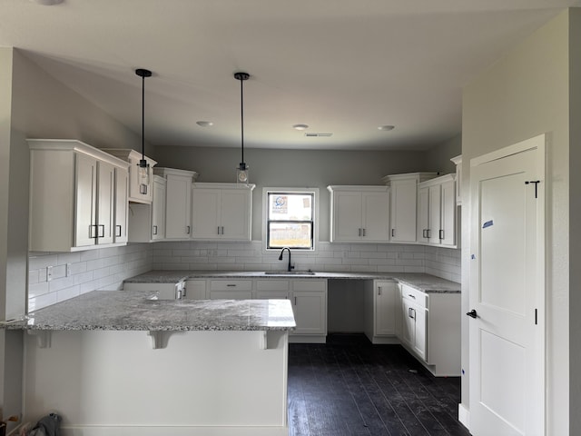 5955 S Farm Rd 163 205A, Springfield, MO 65810 - kitchen with a sink, dark wood-type flooring, light stone counters, a breakfast bar area, and tasteful backsplash