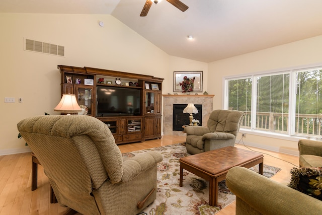 62 Turtledove Ln, Lampe, MO 65681 - living room with vaulted ceiling, ceiling fan, light wood finished floors, a tiled fireplace, and baseboards