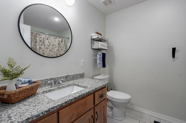 bathroom featuring baseboards, toilet, and vanity