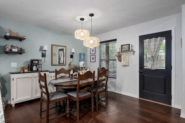 dining area with dark wood-type flooring and baseboards