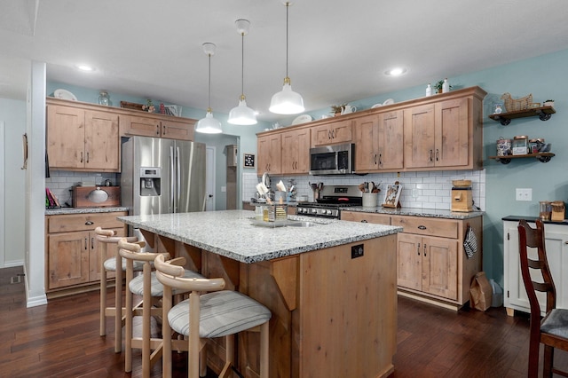 kitchen with stainless steel appliances, tasteful backsplash, a center island, dark wood-type flooring, and recessed lighting
