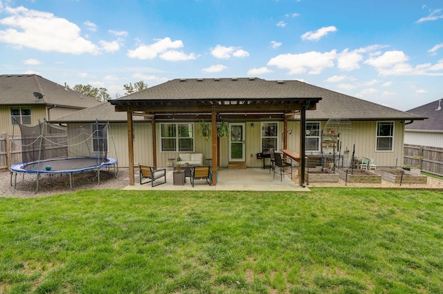 back of house featuring a vegetable garden, a pergola, a patio, a trampoline, and an outdoor living space